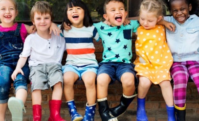 Children With Arms Around Each Other Sitting In A Childcare Centre